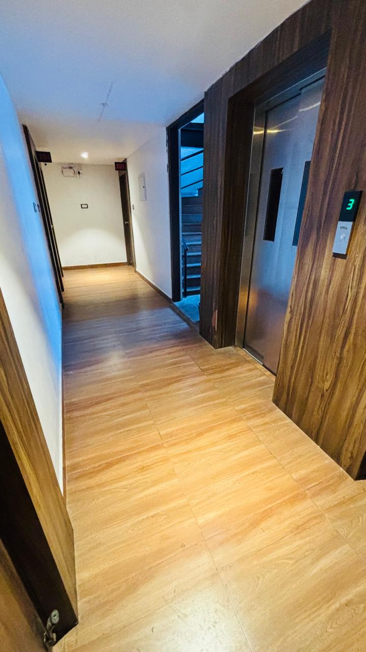 Clean hallway with elevator at Hotel Royal Nest Inn