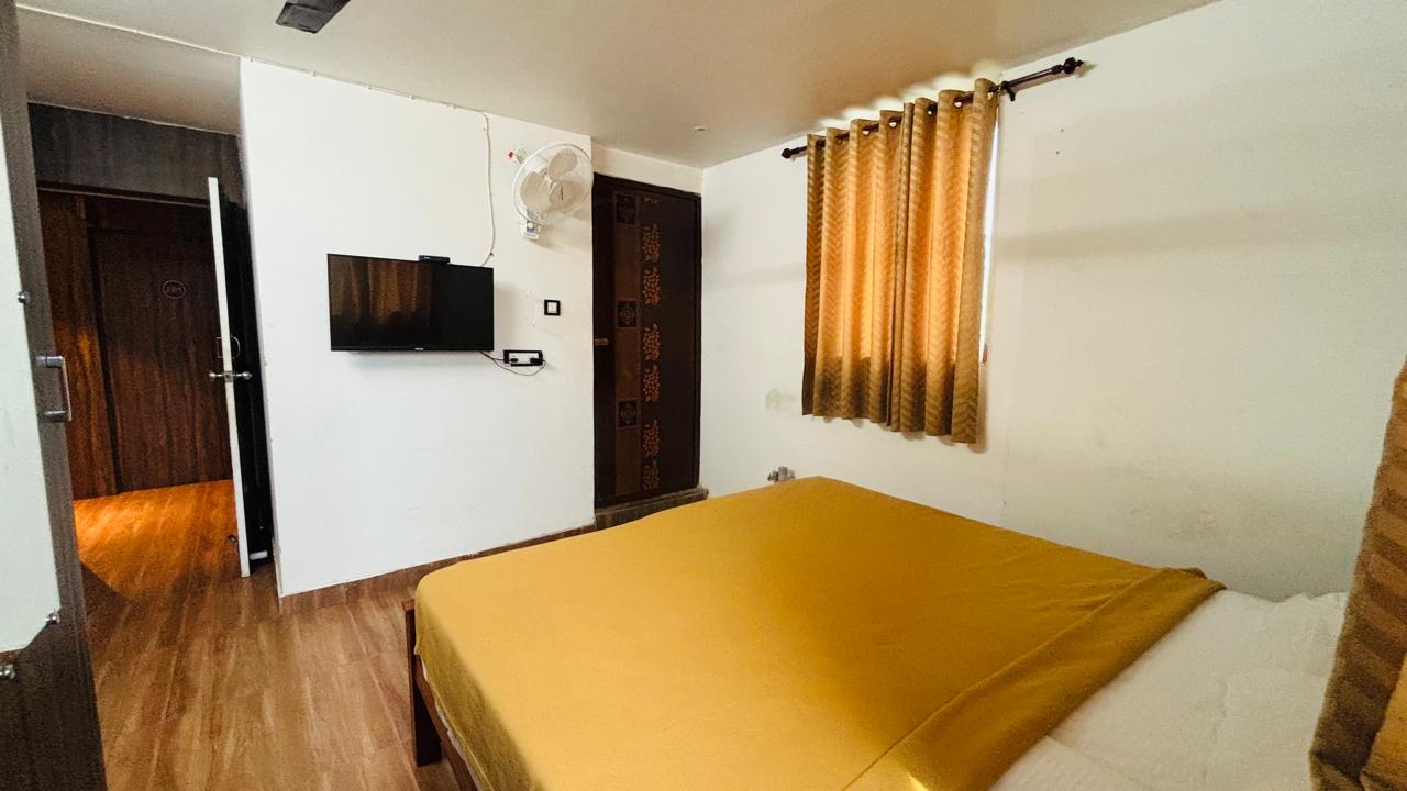 Room with wall-mounted TV and double bed